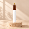 Depiladora facial de precisión Lume Skin, blanca con detalles en oro rosa, sobre pedestal de piedra